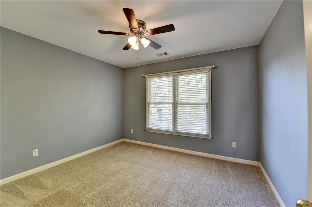 3407 Highland Forge Trail Dacula, GA 30019 - Photo 27 of 71 an empty room with a chandelier fan and windows