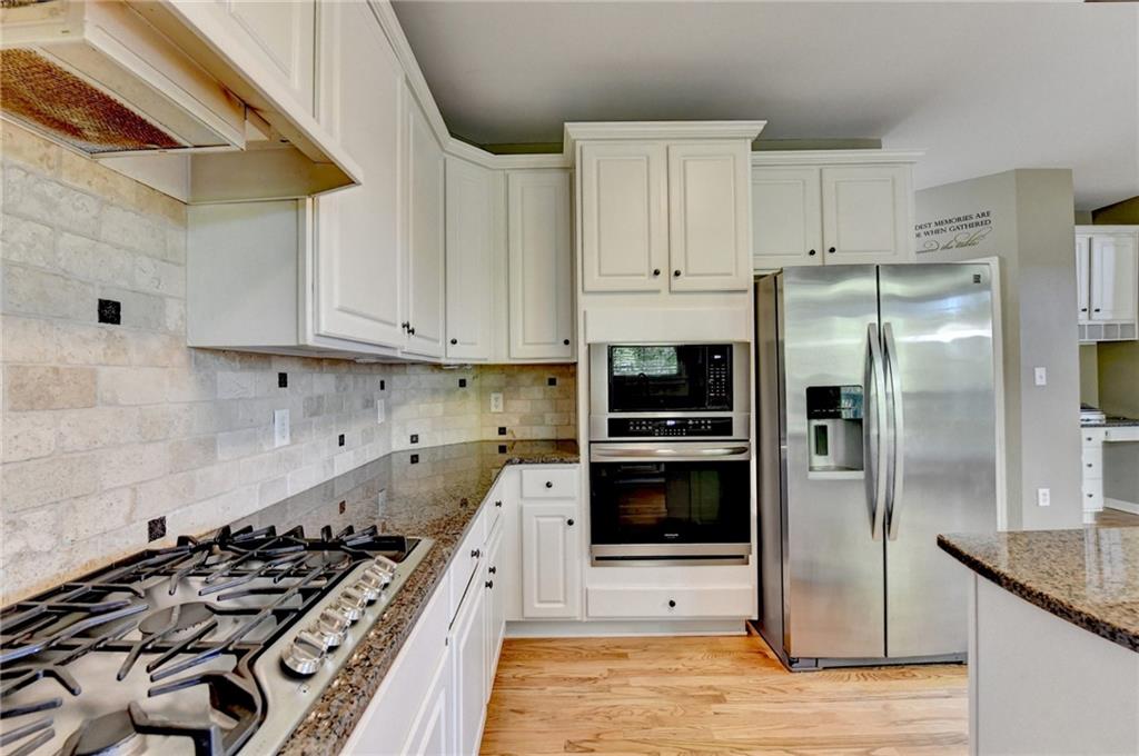 3407 Highland Forge Trail Dacula, GA 30019 - Photo 37 of 71 a kitchen with stainless steel appliances a stove a sink and a refrigerator