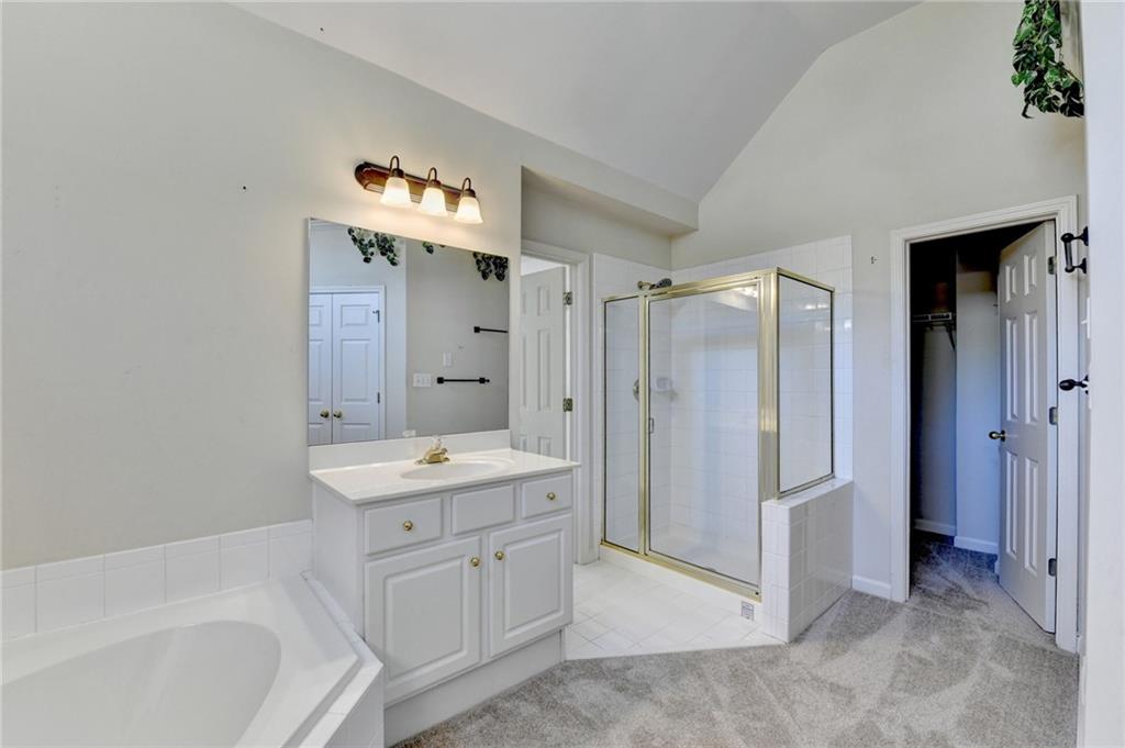 3407 Highland Forge Trail Dacula, GA 30019 - Photo 59 of 71 a en suite bathroom with a double vanity sink a mirror and a bathtub