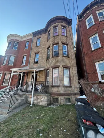 a view of a brick building next to a yard