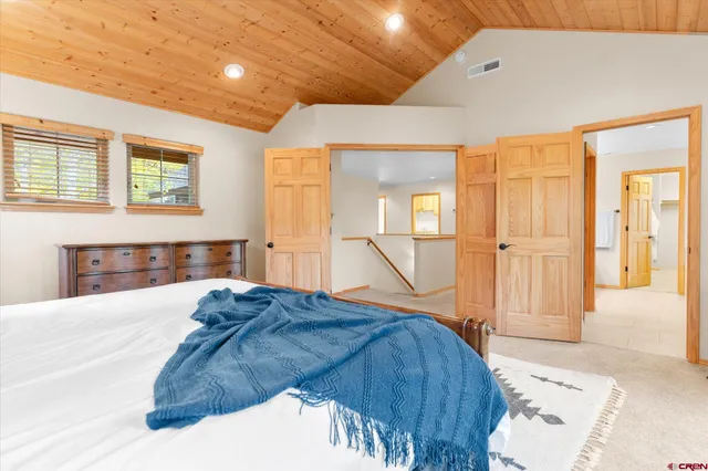 a bedroom with a large bed and wooden floor