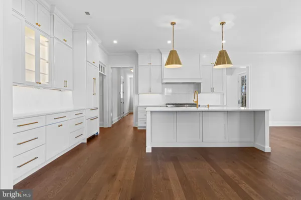 a view of open kitchen with cabinets and wooden floor