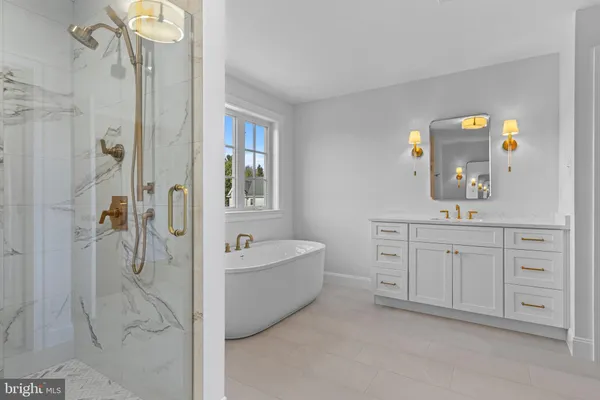 a spacious bathroom with a double vanity sink a mirror a bathtub and shower