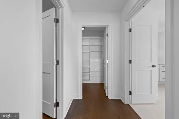 a view of a hallway with wooden floor and closet
