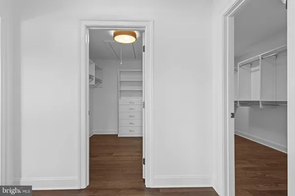 a view of walk in closet with wooden floor