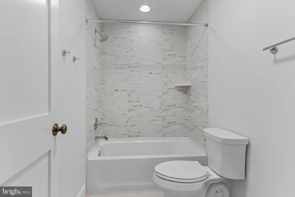 a bathroom with a toilet and a bath tub