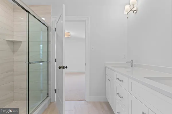 a bathroom with a granite countertop sink a mirror and shower