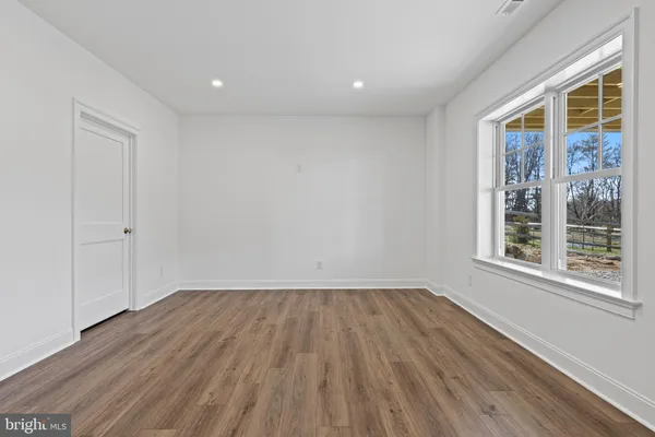 a view of room with window and wooden floor