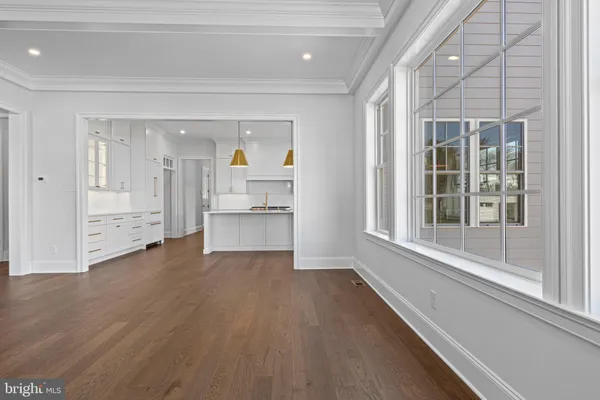 a view of a hallway with wooden floor and a living room