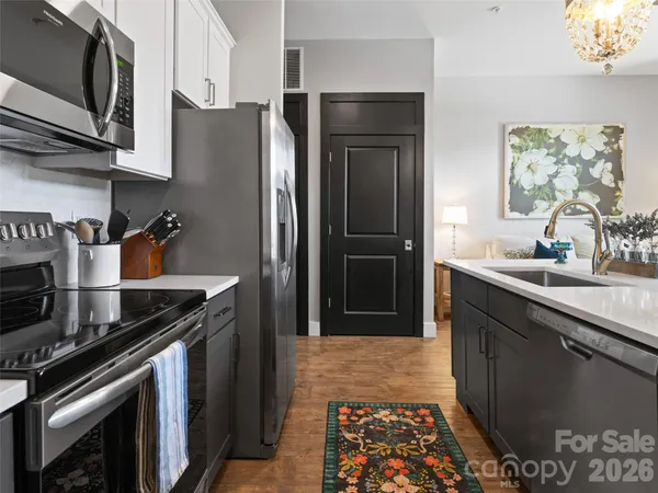 a kitchen with stainless steel appliances granite countertop a refrigerator a stove a sink and a microwave