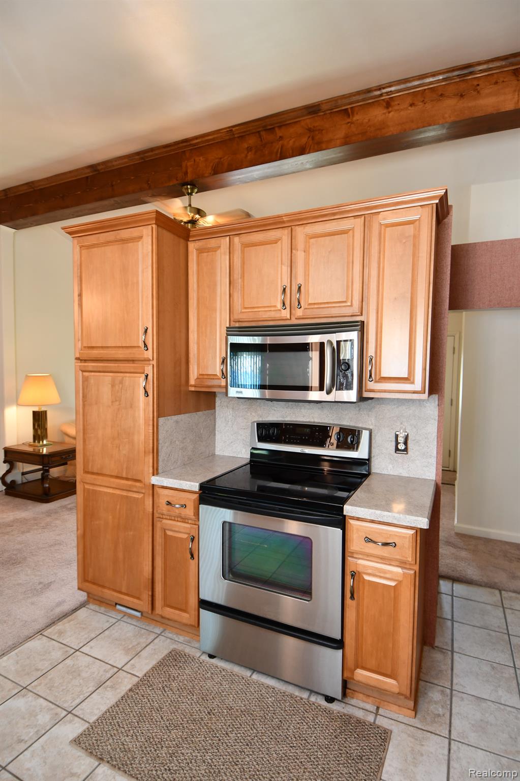 6443 Richfield Road Flint, MI 48506 - Photo 9 of 40 Kitchen with appliances with stainless steel finishes, light tile patterned floors, beam ceiling, and light carpet