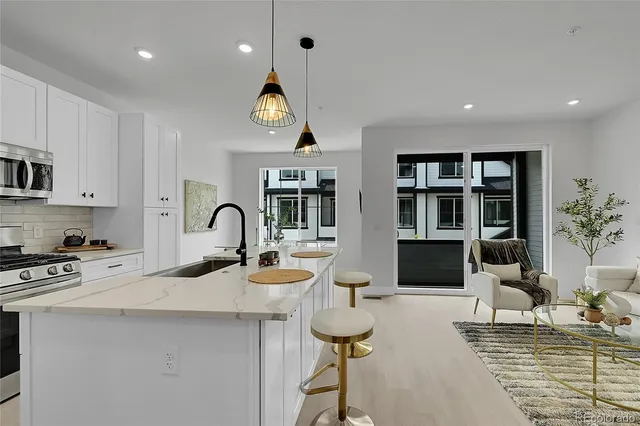 a kitchen with stainless steel appliances kitchen island a stove a sink a refrigerator and cabinets