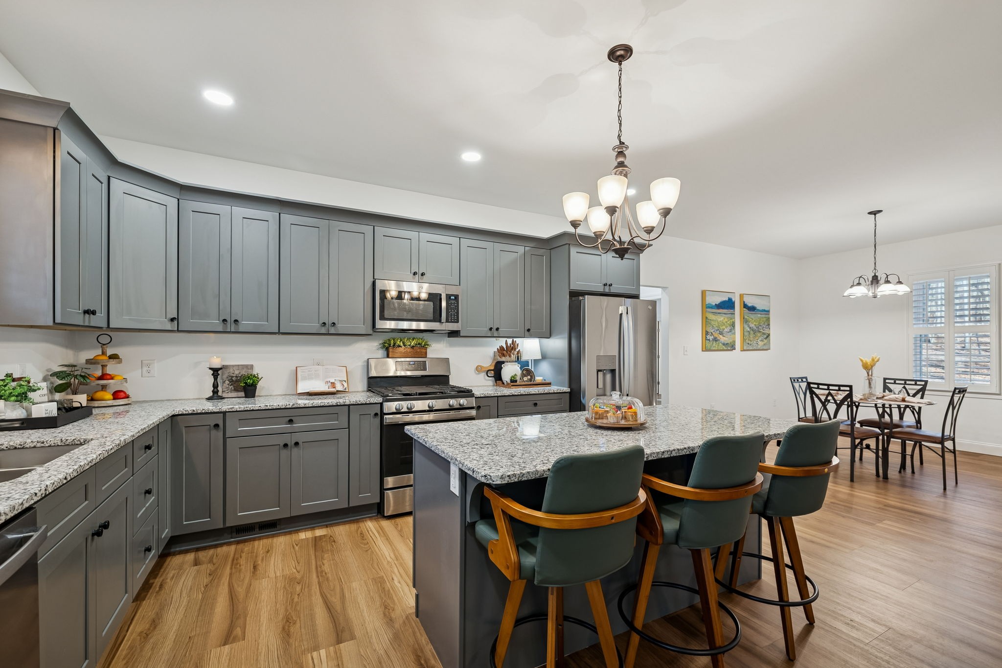 261 Lake Louisa Loop Monteagle, TN 37356 - Photo 16 of 49 a kitchen with stainless steel appliances granite countertop a stove top oven a sink a dining table and chairs with wooden floor