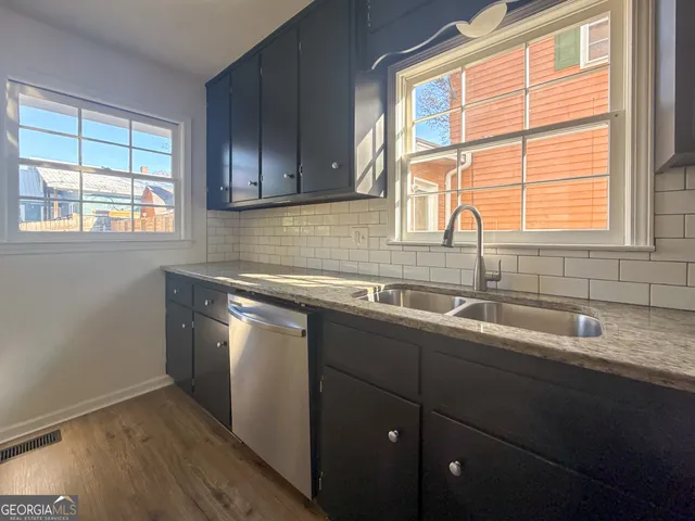 a kitchen with stainless steel appliances wooden cabinets a sink and a window