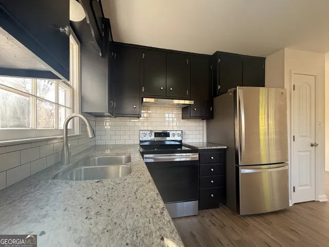 a kitchen with a refrigerator sink and wooden cabinets