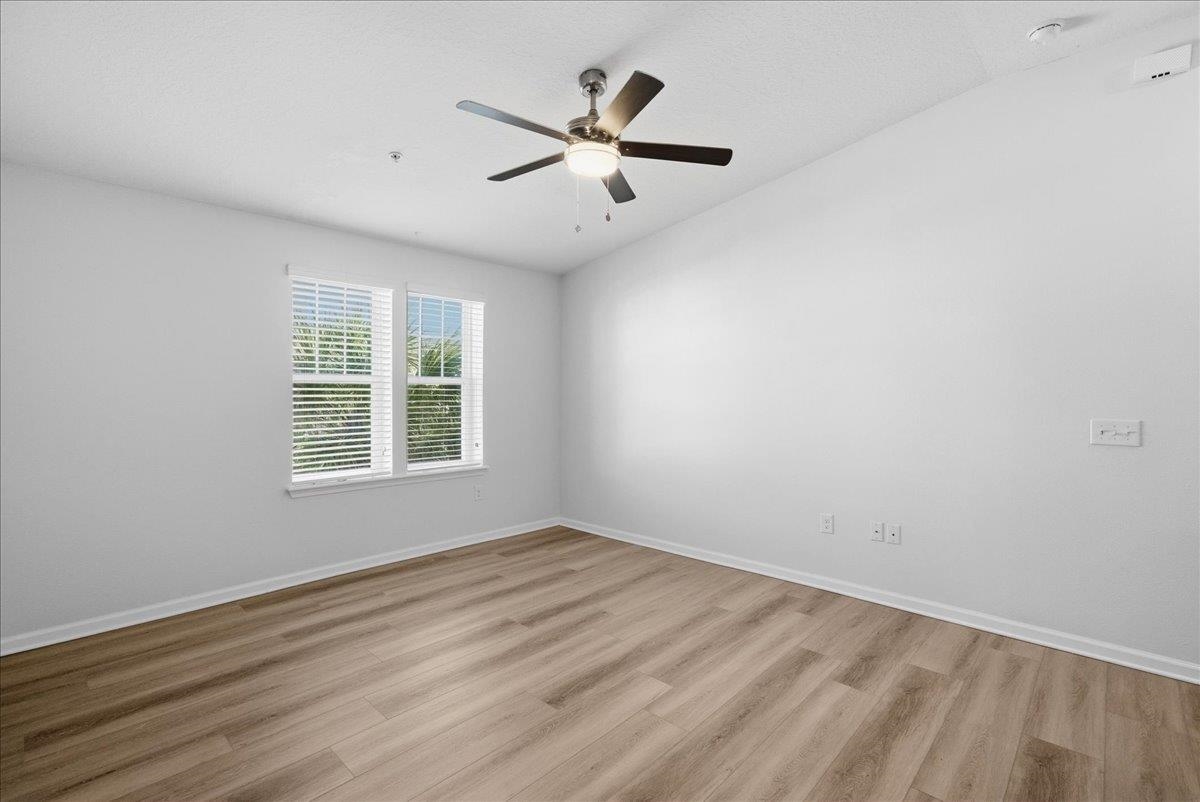 1112 Golden Lake Loop St. Augustine, FL 32084 - Photo 16 of 56 an empty room with wooden floor and windows