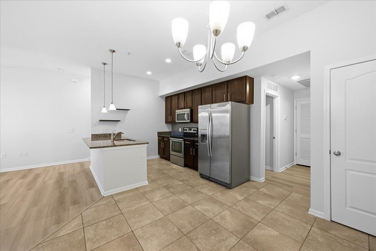 1112 Golden Lake Loop St. Augustine, FL 32084 - Photo 20 of 56 a kitchen with granite countertop a refrigerator a stove a microwave and cabinets