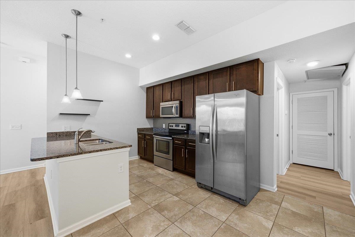 1112 Golden Lake Loop St. Augustine, FL 32084 - Photo 21 of 56 a kitchen with stainless steel appliances granite countertop a refrigerator a sink a stove and a refrigerator