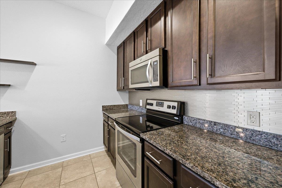 1112 Golden Lake Loop St. Augustine, FL 32084 - Photo 23 of 56 a kitchen with granite countertop cabinets washer and dryer