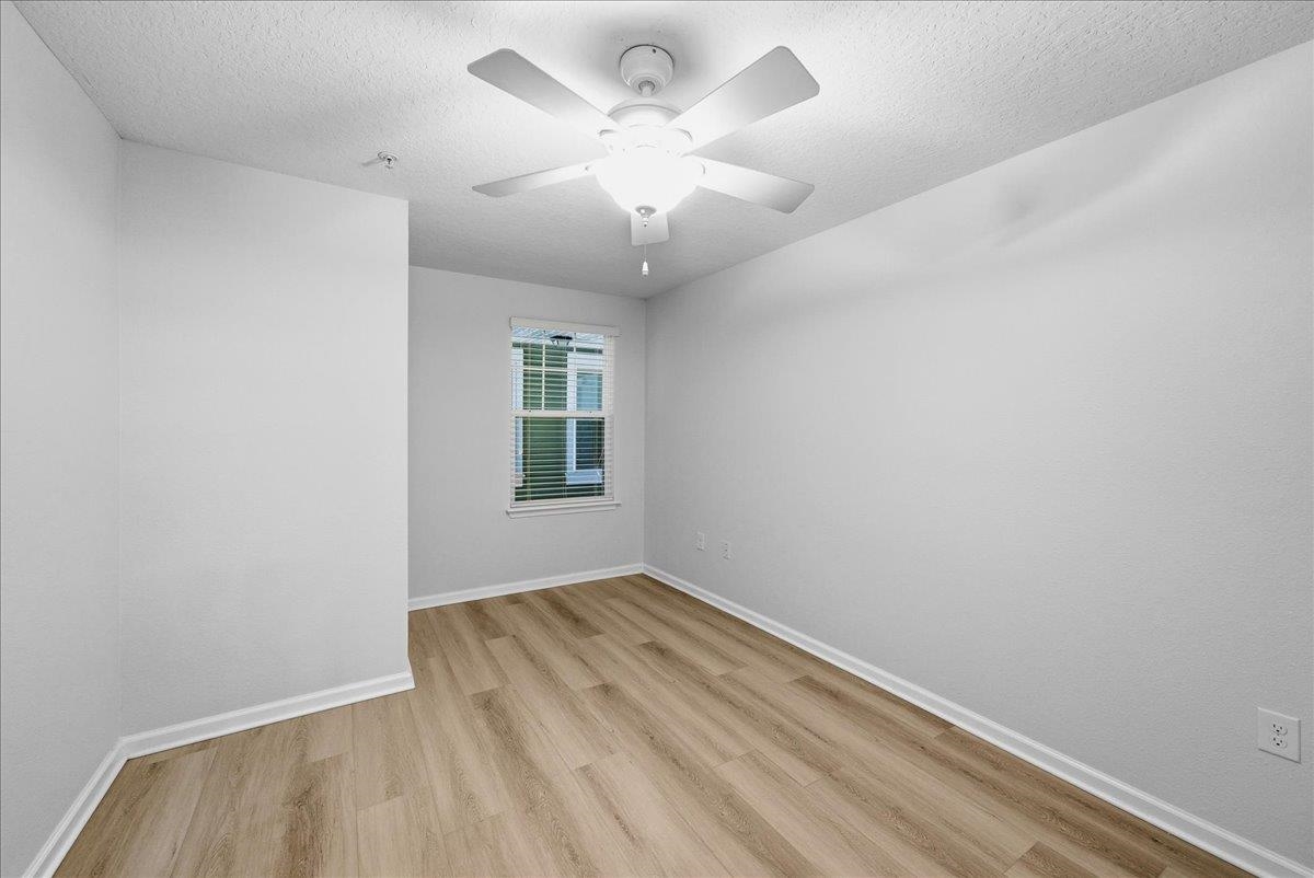 1112 Golden Lake Loop St. Augustine, FL 32084 - Photo 28 of 56 an empty room with a chandelier fan and windows