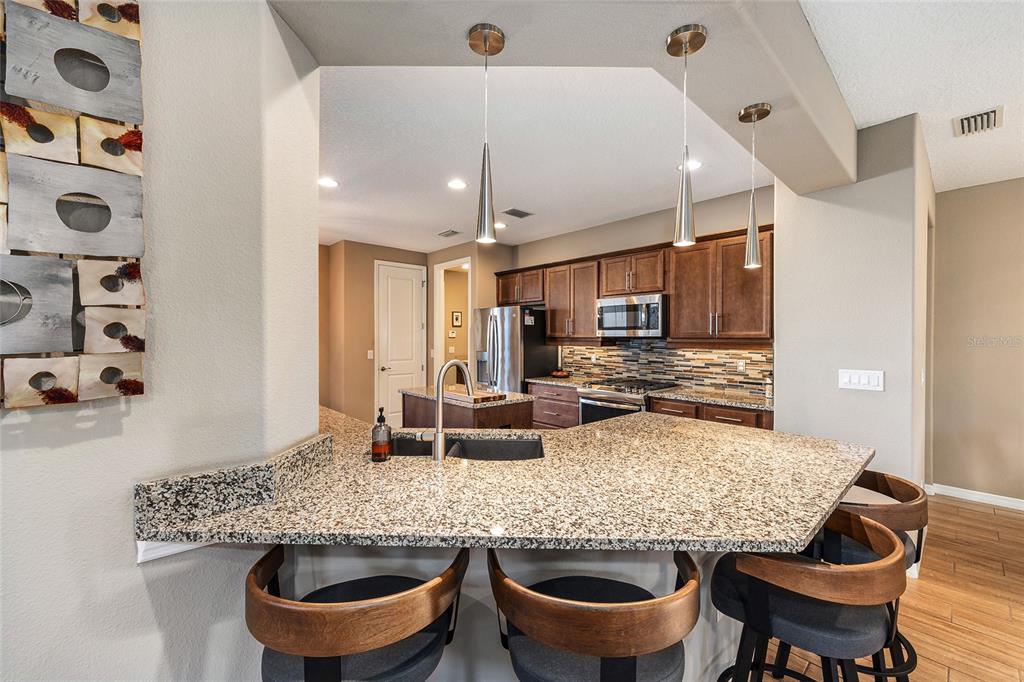 5589 Northwest 40th Loop Ocala, FL 34482 - Photo 17 of 47 a kitchen with granite countertop a table chairs stove and cabinets