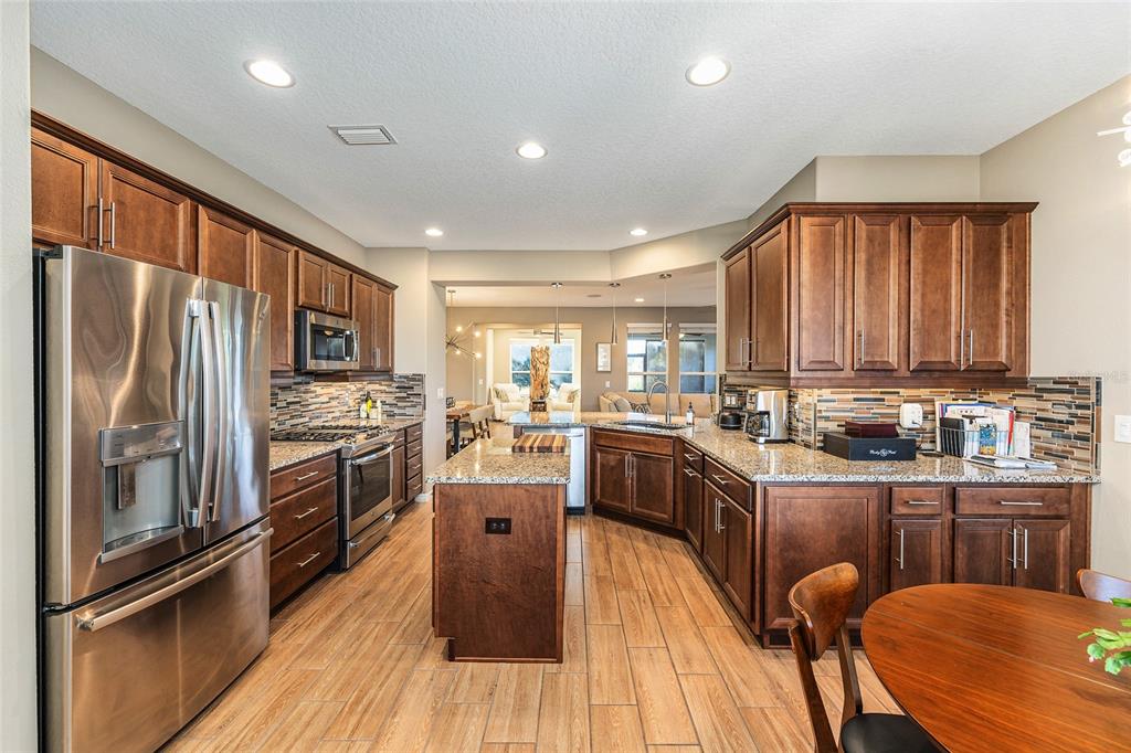 5589 Northwest 40th Loop Ocala, FL 34482 - Photo 18 of 47 a kitchen with granite countertop a refrigerator stove and sink