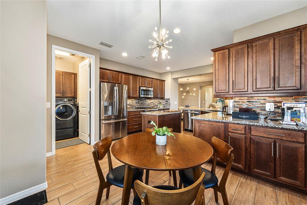 5589 Northwest 40th Loop Ocala, FL 34482 - Photo 20 of 47 a kitchen with refrigerator a stove dining table and chairs