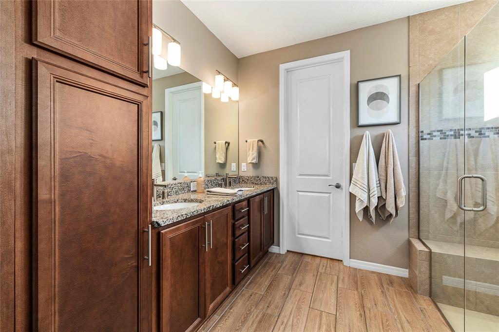 5589 Northwest 40th Loop Ocala, FL 34482 - Photo 28 of 47 a bathroom with a granite countertop shower a sink and a mirror