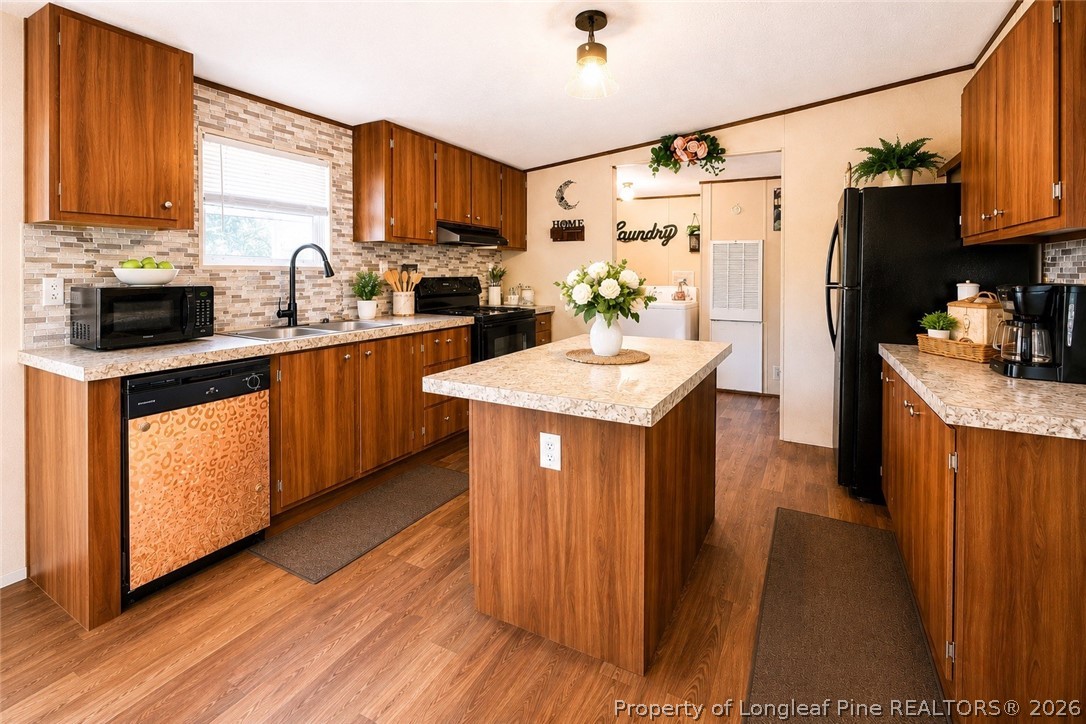 466 Ralph Hunt Boulevard Orrum, NC 28369 - Photo 5 of 17 a kitchen with stainless steel appliances granite countertop a refrigerator a sink dishwasher a stove with wooden cabinets and floor