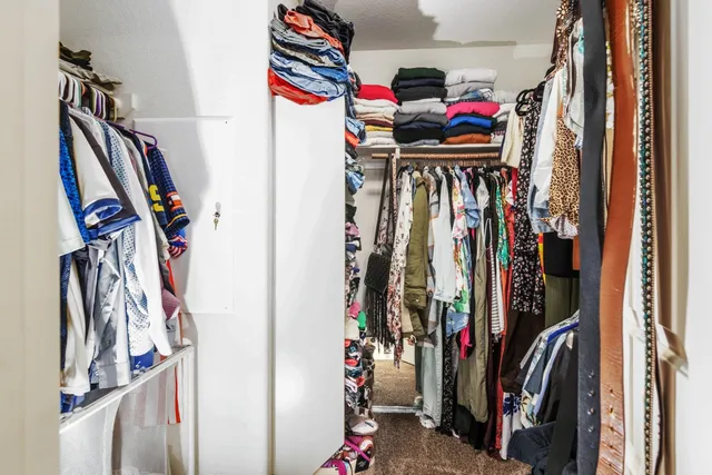 a view of walk in closet with clothes