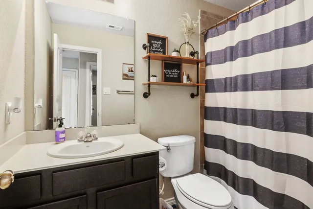 a bathroom with a sink a toilet a shower and a mirror