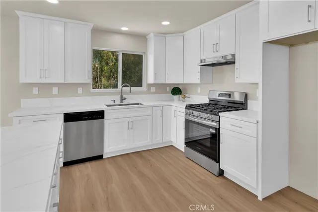 a kitchen with white cabinets stainless steel appliances and sink