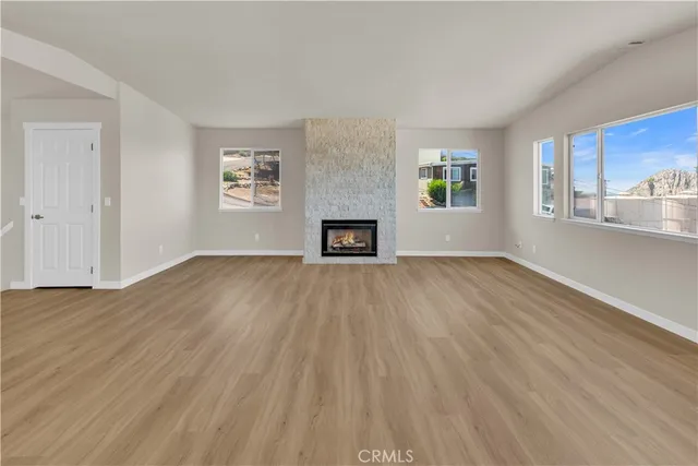 a view of a kitchen with wooden floor and windows