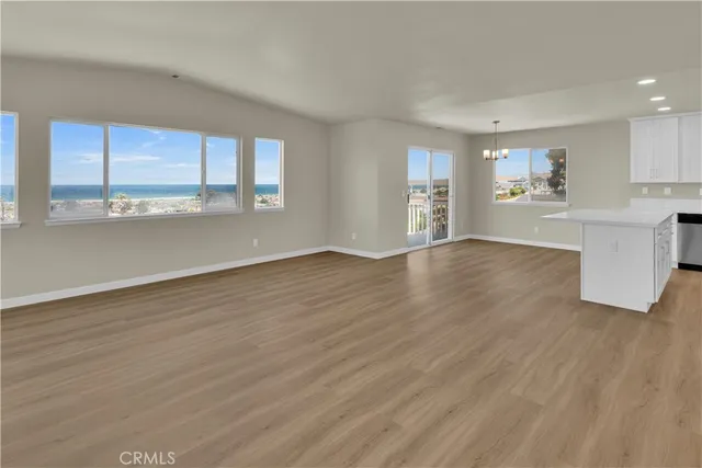 a view of a big room with wooden floor and windows