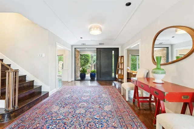 a large living room with stainless steel appliances furniture a rug and a large window