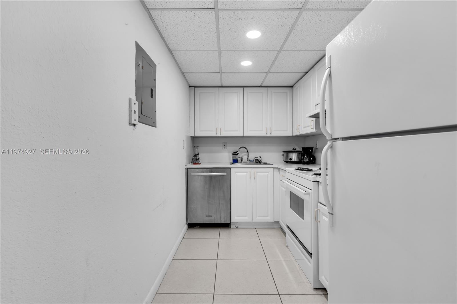 17530 Northwest 68th Avenue, Unit C2003 Hialeah, FL 33015 - Photo 12 of 20 a kitchen with white cabinets and white appliances