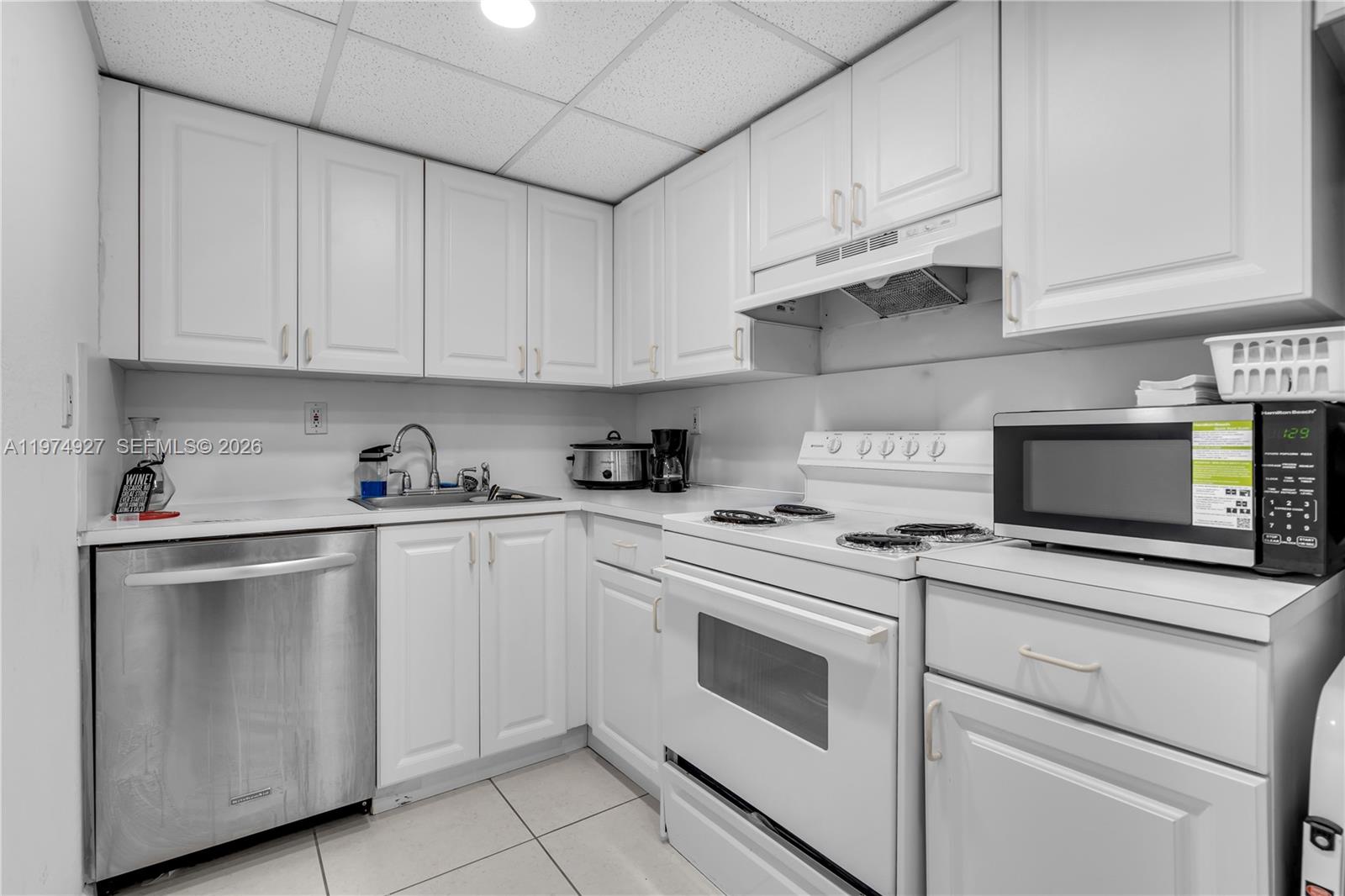 17530 Northwest 68th Avenue, Unit C2003 Hialeah, FL 33015 - Photo 13 of 20 a kitchen with cabinets stainless steel appliances and sink