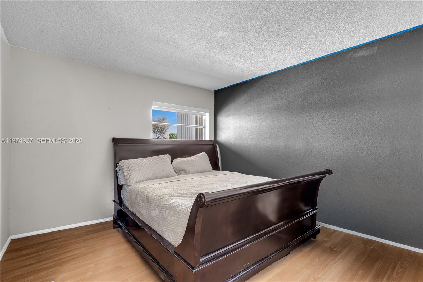 17530 Northwest 68th Avenue, Unit C2003 Hialeah, FL 33015 - Photo 15 of 20 a bed sitting in a bedroom next to a cabinet