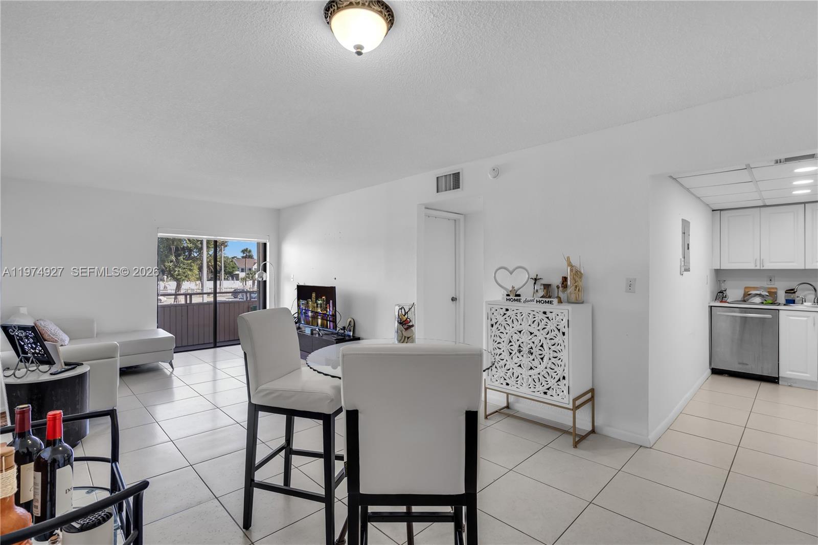 17530 Northwest 68th Avenue, Unit C2003 Hialeah, FL 33015 - Photo 8 of 20 a view of a dining room with furniture and chandelier