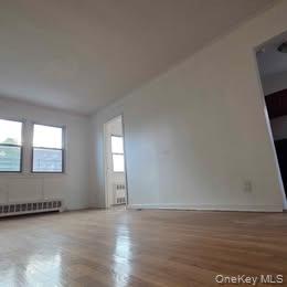 38-21 149th Place Queens, NY 11354 - Photo 3 of 11 a view of an empty room with wooden floor and a window