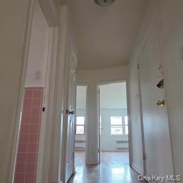 38-21 149th Place Queens, NY 11354 - Photo 6 of 11 a view of a hallway with wooden floor and a bathroom