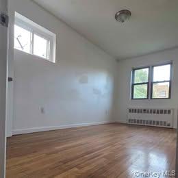 38-21 149th Place Queens, NY 11354 - Photo 8 of 11 an empty room with wooden floor and windows
