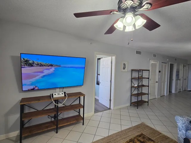 a view of a livingroom with furniture and chandelier fan