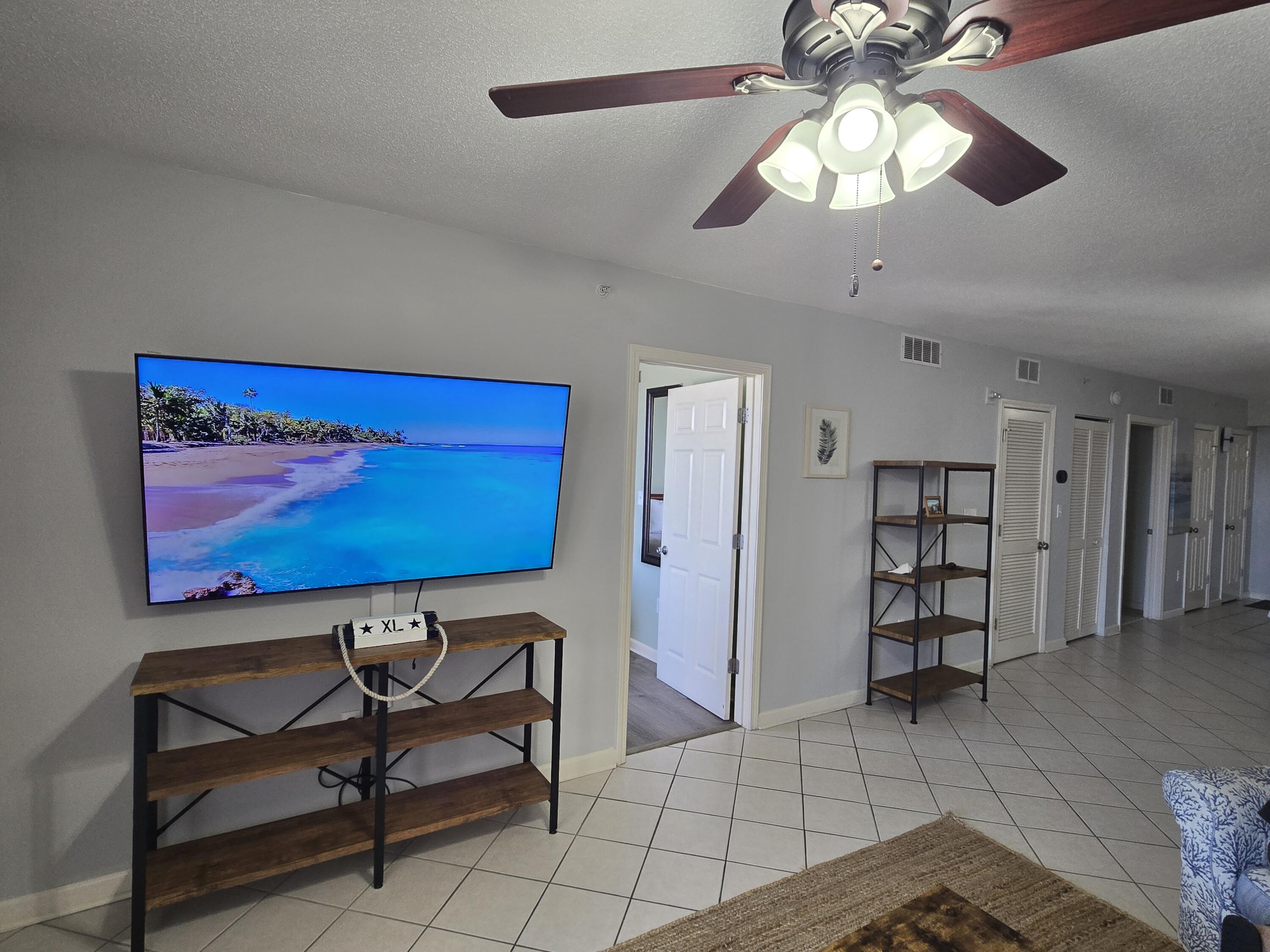 a view of a livingroom with furniture and chandelier fan