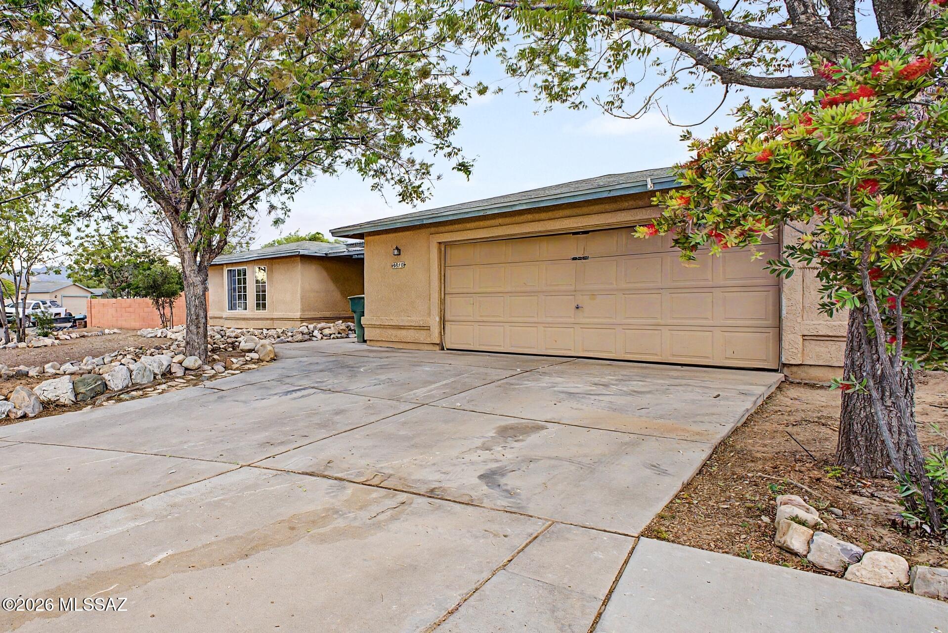 9810 East Stonehaven Way Tucson, AZ 85747 - Photo 6 of 27 a front view of a house with a yard and garage