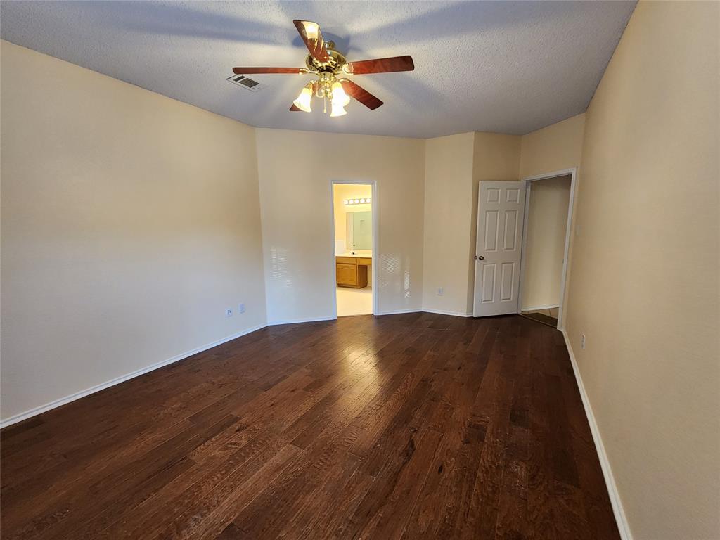 2413 Timber Ridge Lane Flower Mound, TX 75028 - Photo 18 of 32 Spacious room featuring rich wood-finish flooring, light-toned walls, and a ceiling fan with integrated lighting