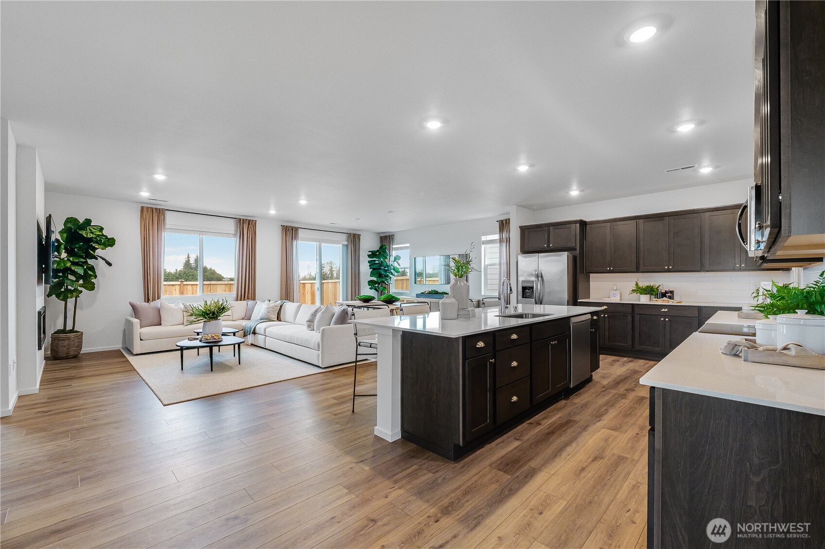 132 Moonshadow Lane Sequim, WA 98382 - Photo 4 of 28 a large kitchen with stainless steel appliances a large counter top a sink a stove a dining table and chairs