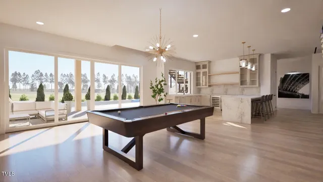 a room with stainless steel appliances kitchen island granite countertop a stove a refrigerator a dining table and chairs with wooden floor