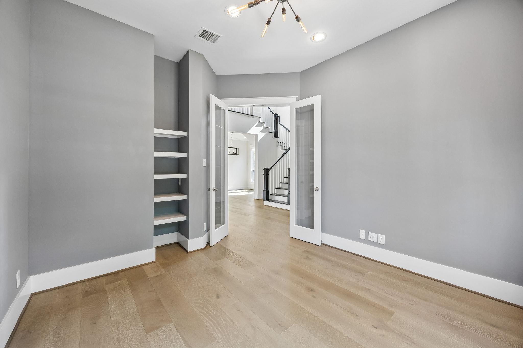 8558 Ridgepoint Drive Houston, TX 77055 - Photo 15 of 39 A linear pendant anchors the dining area, while wood floors and open sightlines connect it to the entry and staircase.