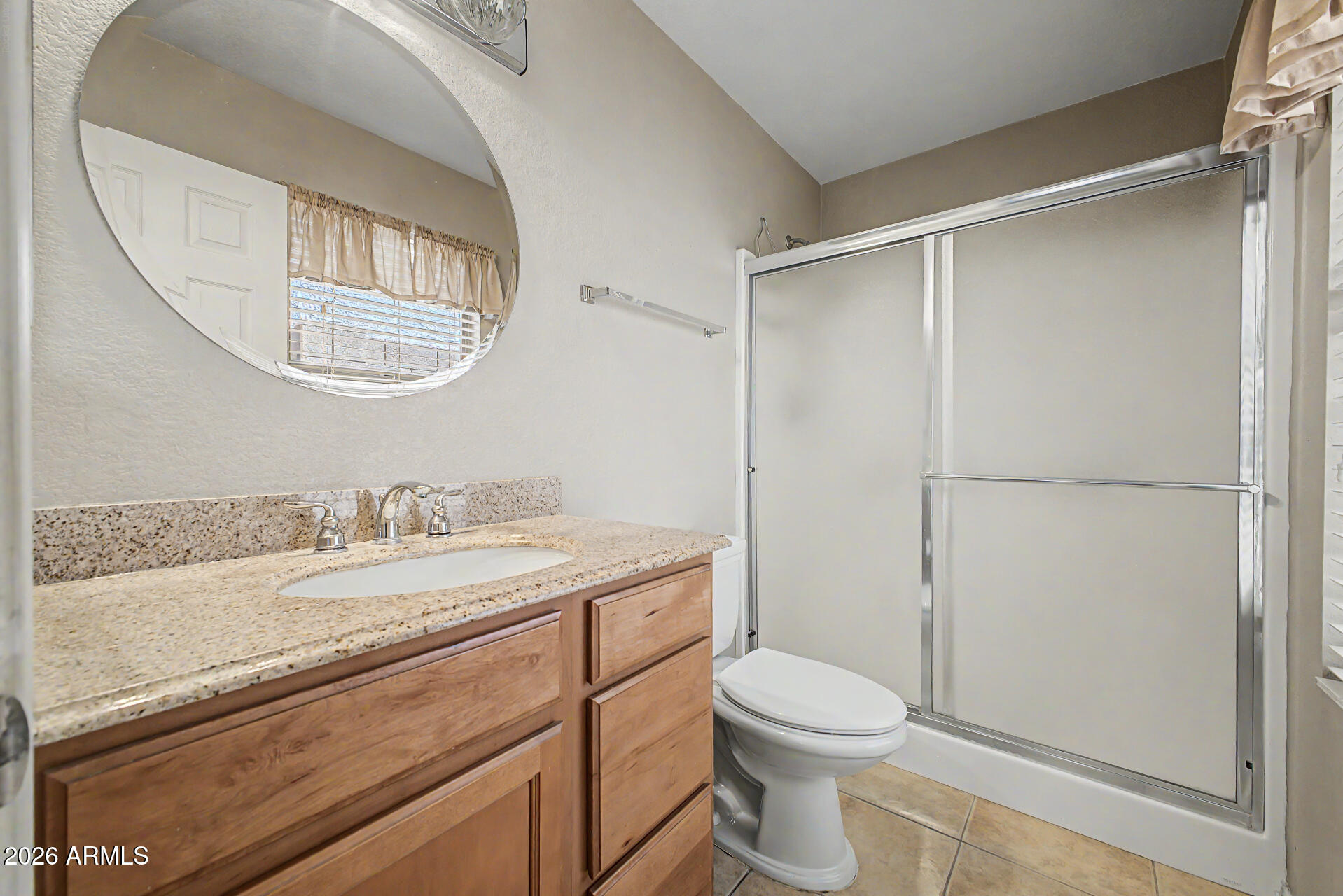 3489 South Bowman Road Apache Junction, AZ 85119 - Photo 5 of 24 a bathroom with a granite countertop sink toilet a mirror and a shower